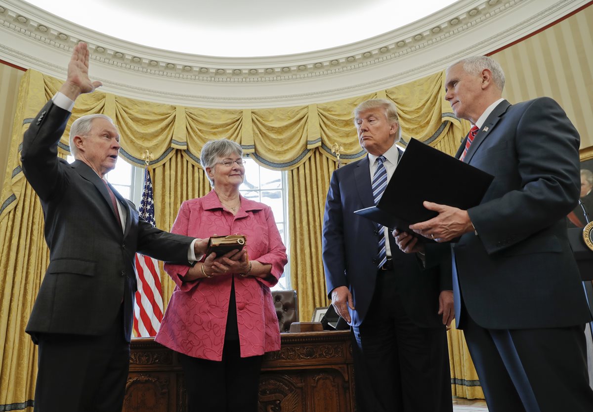 Trump observa como Mike Pence juramenta al Fiscal General Jeff Sessions en la Oficina Oval. (Foto Prensa Libre: AP).