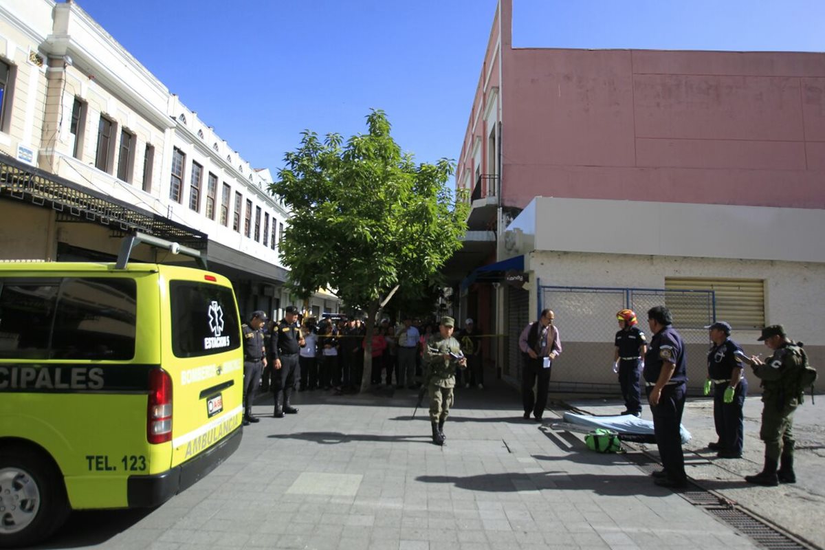 El cuerpo de un hombre quedó tendido en el ingreso a un parqueo en la 6a. avenida, entre 9a. y 10a. calle de la zona 1. (Foto Prensa Libre: Edwin Bercián)