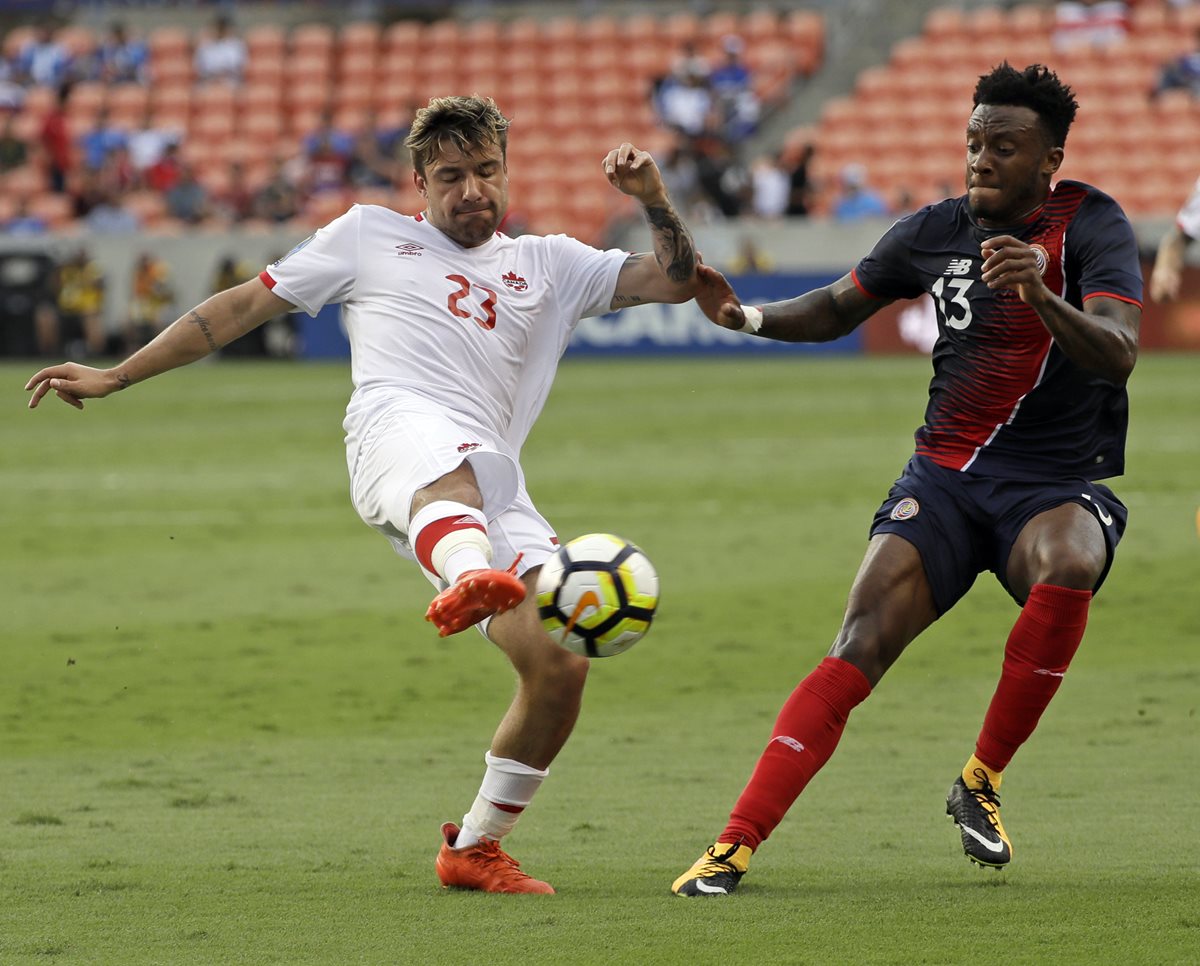 El canadiense Michael Petrasso intenta un despeje ante la marca del tico Rodney Wallace.