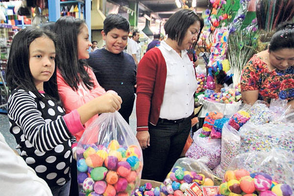 Familias adquieren cascarones para celebrar la fiesta del carnaval.