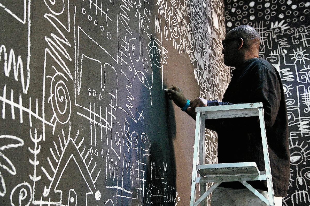 El artista nigeriano Victor EkPuk trabaja en su obra "Meditation on memory" durante la bienal inaugurada este sábado. (Foto Prensa Libre: EFE)