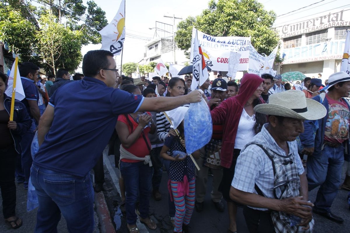 Algunas personas regalan agua a quienes manifiestan.