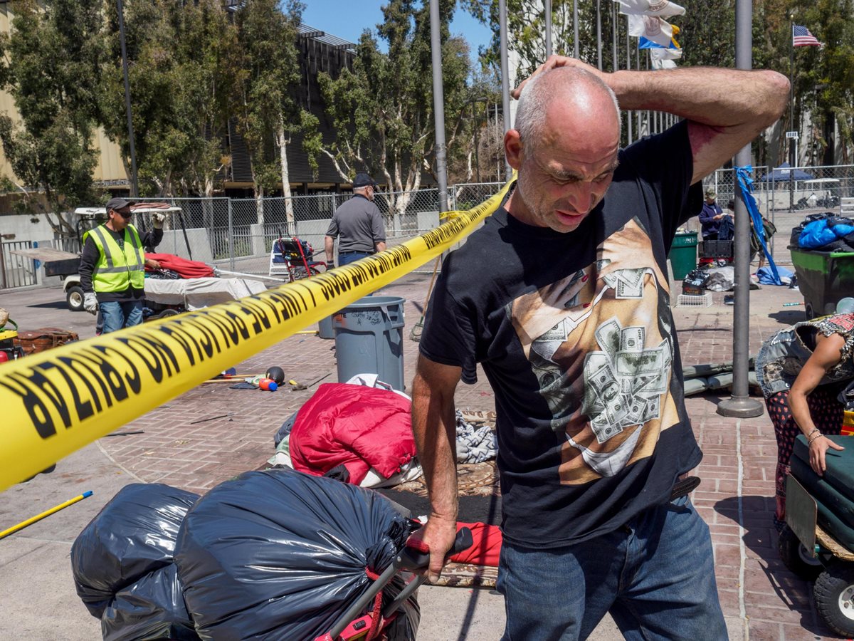 Mark West sale con un carrito con sus pertenencias de un campamento de personas sin hogar en Santa Ana, California, EE.UU.(EFE).