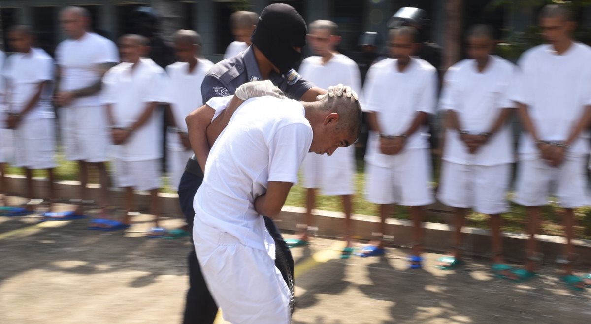 Un integrante de la pandilla es escoltado al llegar a una prisión de máxima seguridad. (Foto Prensa Libre: AFP)