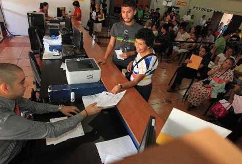 Dos empleados del Renap atienden a más de 200 personas que solicitan  certificado de nacimiento, en la sede que funciona en el edificio Real del Parque, zona 1.