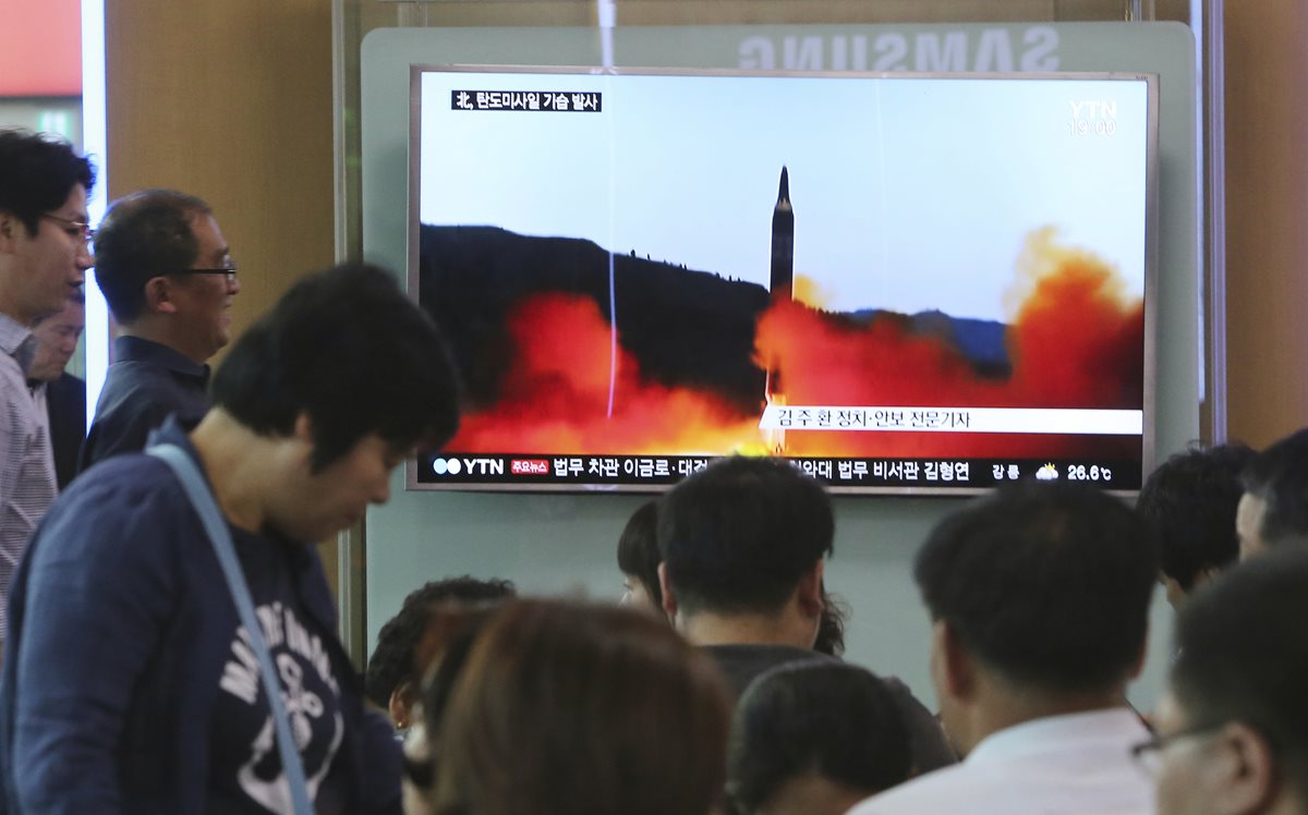 Personas observan noticiero con imagen de un misil lanzado por Corea del Norte. (Foto Prensa Libre: AP)