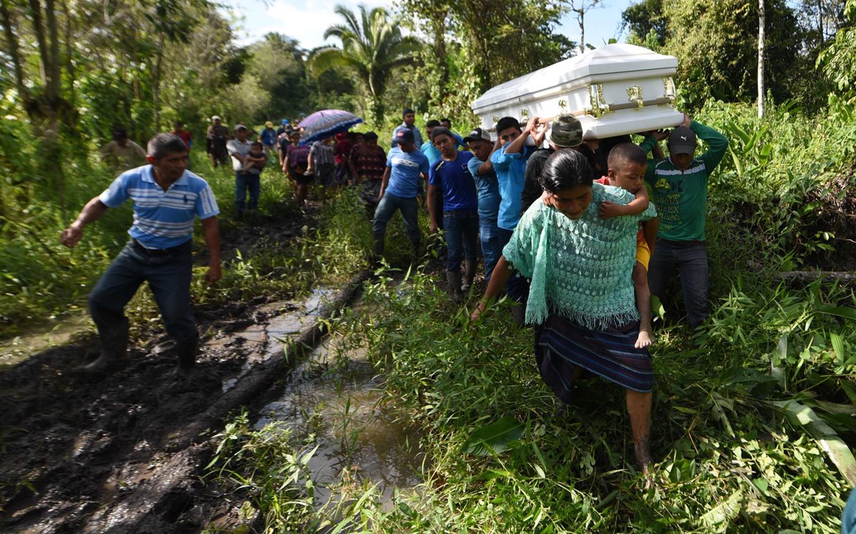 Las personas que acompañan el cuerpo de Jakelin Caal se desplazan por un camino rural en Raxruhá, Alta Verapaz, rumbo al cementerio.