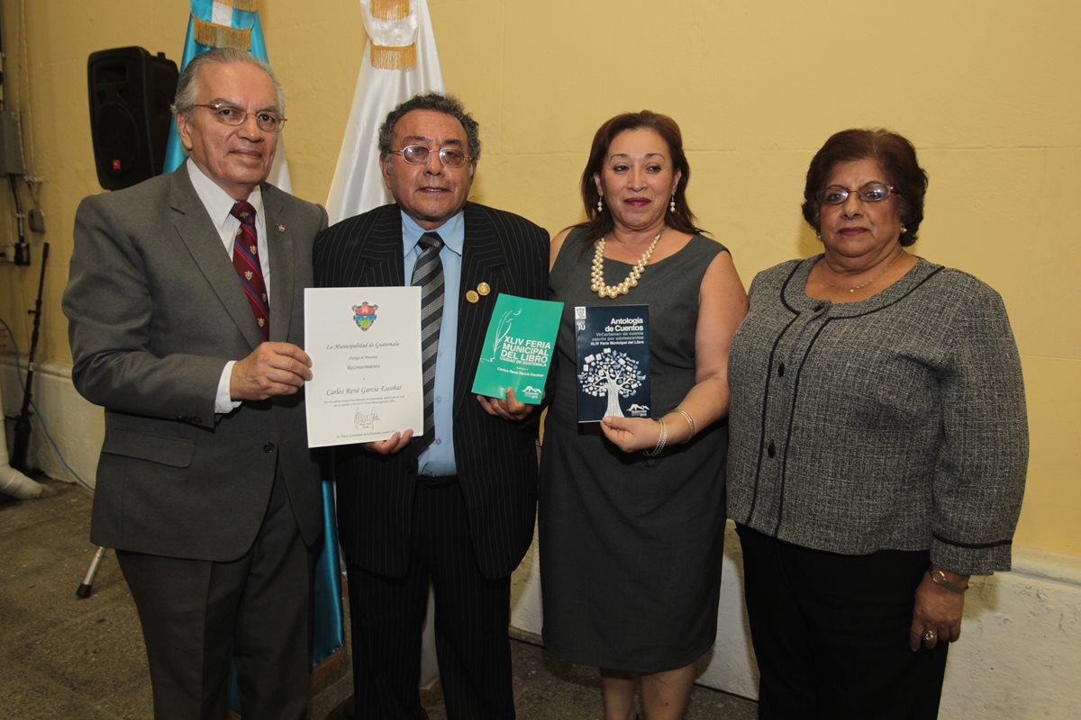 Rogelio Rivera, del Consejo Cultural de la Muni y Carlos René García Escobar, homenajeado, junto a Heidy de León y Carmen de León, de la editorial Óscar de León Castillo. (Foto Prensa Libre: Edwin Castro)