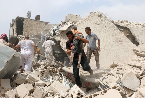 Un sirio lleva a un niño herido por el ataque con bomba barril en Bab al-Nairab de Alepo.(Foto Prensa Libre: AFP)