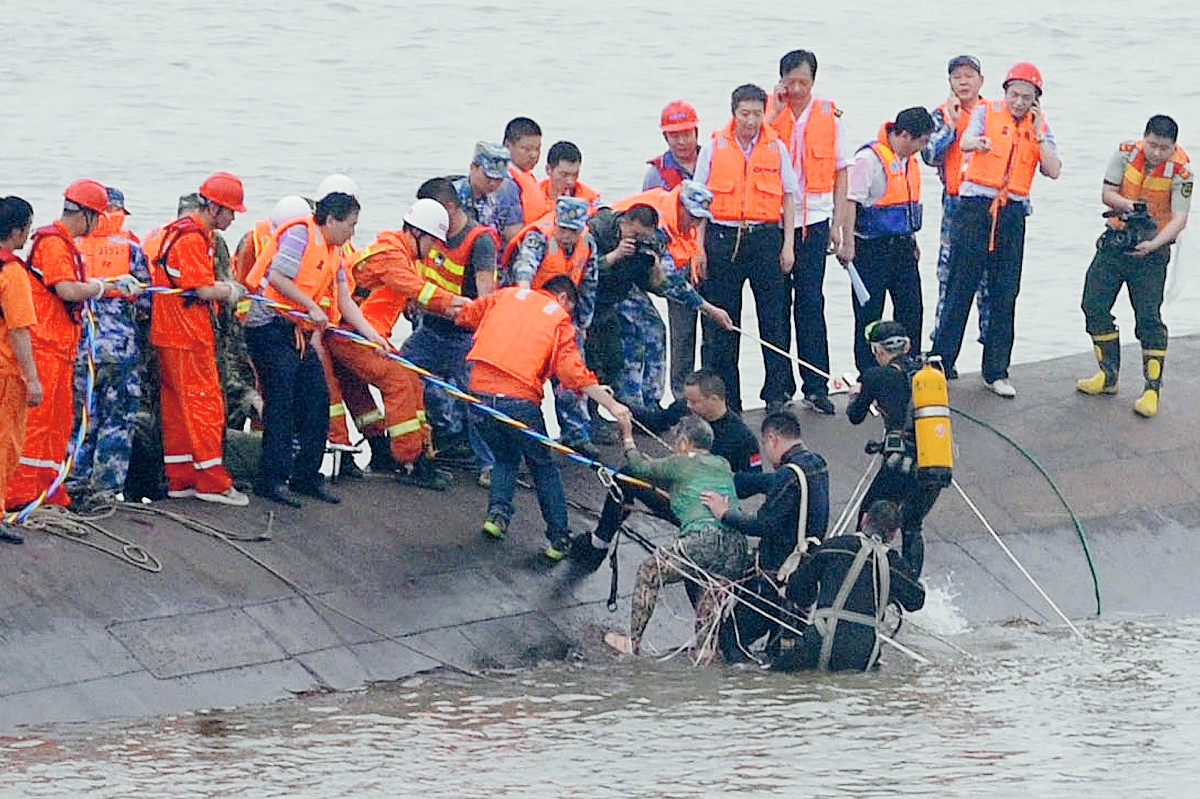 Un sobreviviente es rescatado por buzos en el río Yangtze en Jianli,China. (Foto Prensa LIbre: AFP).