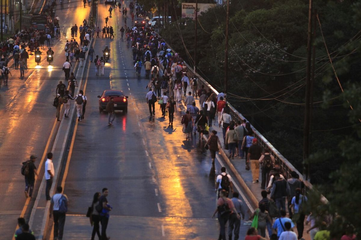 Vecinos caminan por el puente Belice para superar el bloqueo y continuar hacia su destino. (Foto Prensa Libre: Edwin Bercián)