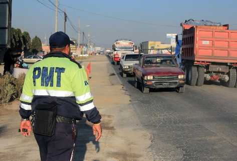 Agente regula tránsito en una carretera de Quetzaltenango.