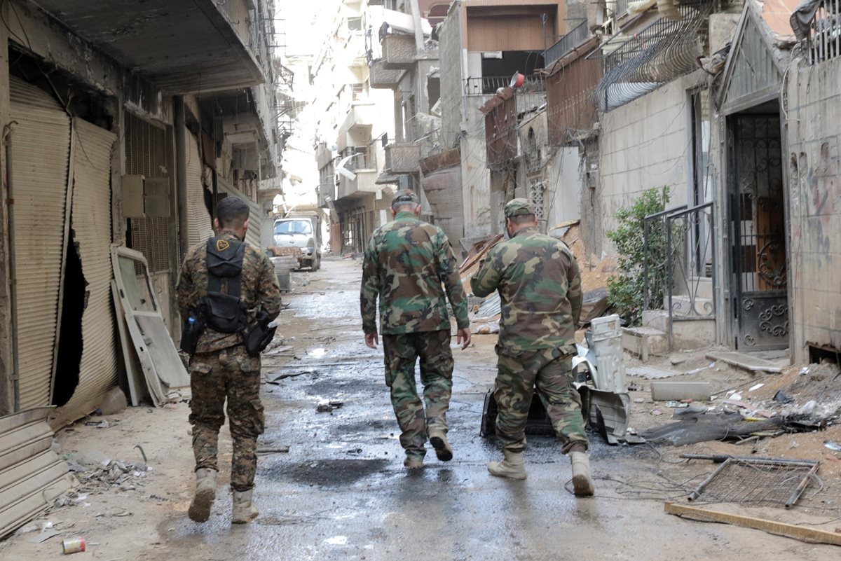 Soldados caminan en la zona donde ocurrió el Ataque en Siria. (Foto Prensa Libre: EFE)