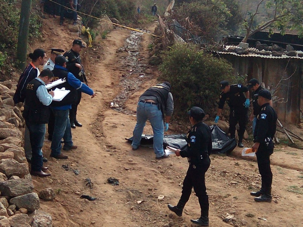 Peritos del Ministerio Público recaban evidencias en el lugar donde se encuentra el cuerpo de Juan Lucero. (Foto Prensa Libre: Hugo Oliva)