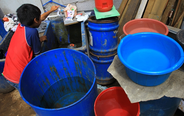 Una niño de la familia Parra Fernández, de la colonia San Roque, Ciudad Satélite, zona 9 de Mixco, abre la llave de chorro en señal que no hay agua en su hogar. (Foto Prensa Libre: Álvaro Interiano)