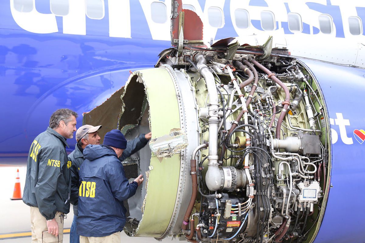 Un grupo de investigadores examinan el daño en un motor del vuelo 1380 de Southwest Airlines. (AFP).