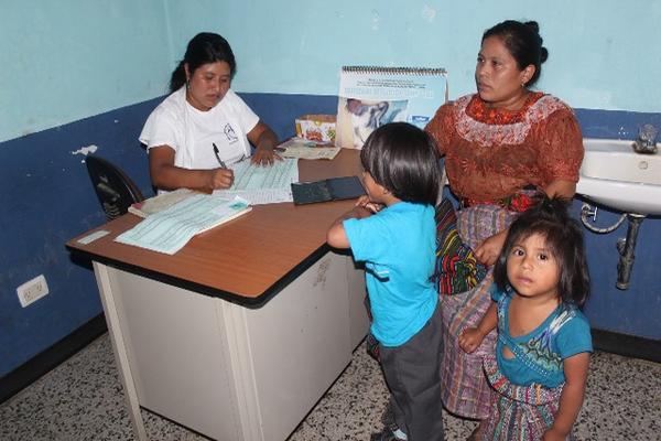 Una madre lleva a sus dos hijos a consulta en el el Puesto de Salud del caserío Samabaj, Guineales. (Foto Prensa Libre: Danilo López)