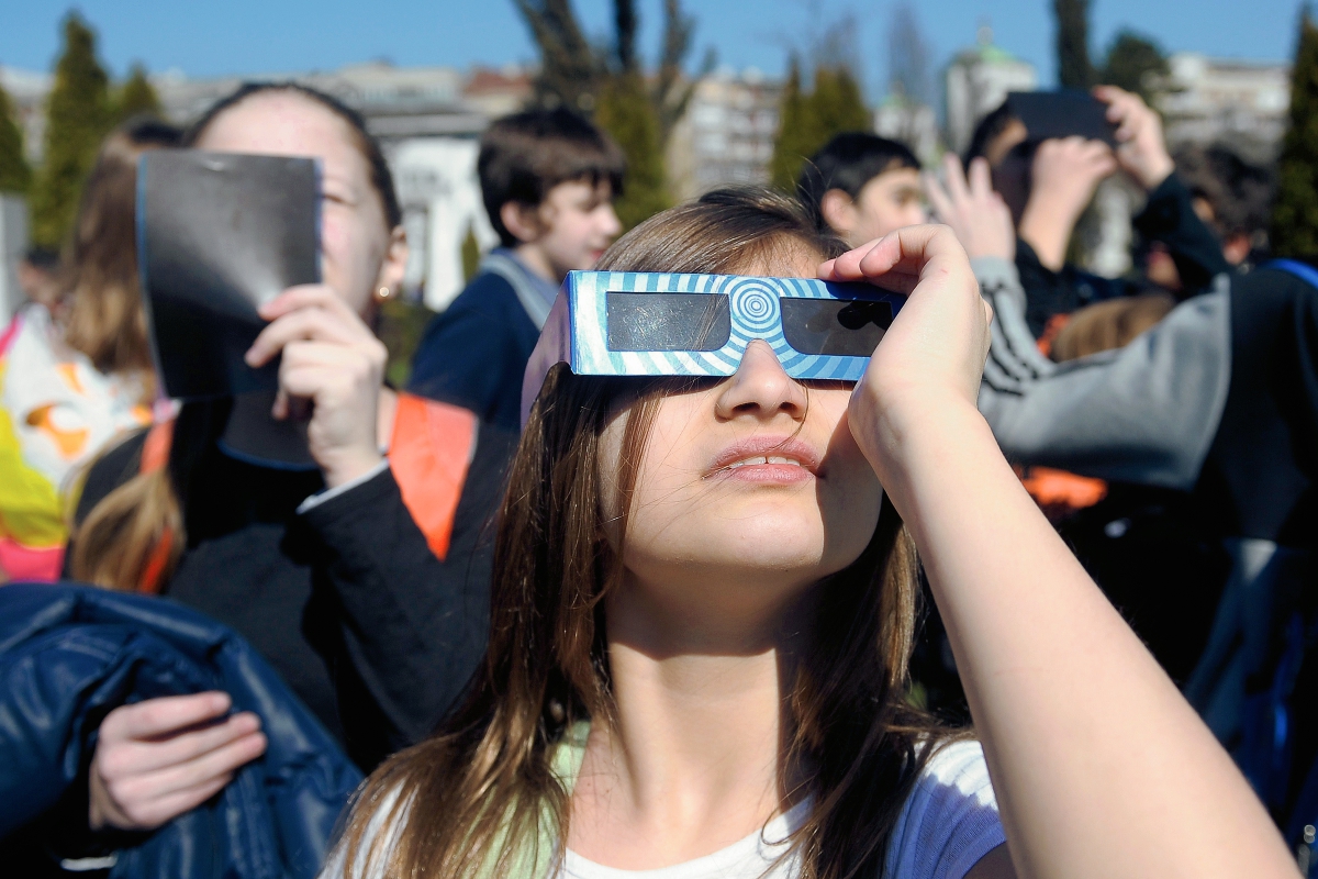 Varias personas observan el eclipse de Sol en Belgrado. (Foto Prensa Libre:AFP).AFP