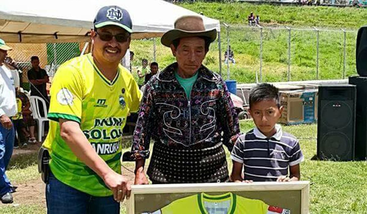 El presidente del Deportivo Sololá, Andres Iboy, entrega el reconocimiento a don Antonio Toc y su hijo Esbin Asael Toc Jiatz como socios honorarios. (Foto Prensa Libre: Ángel Julajuj)