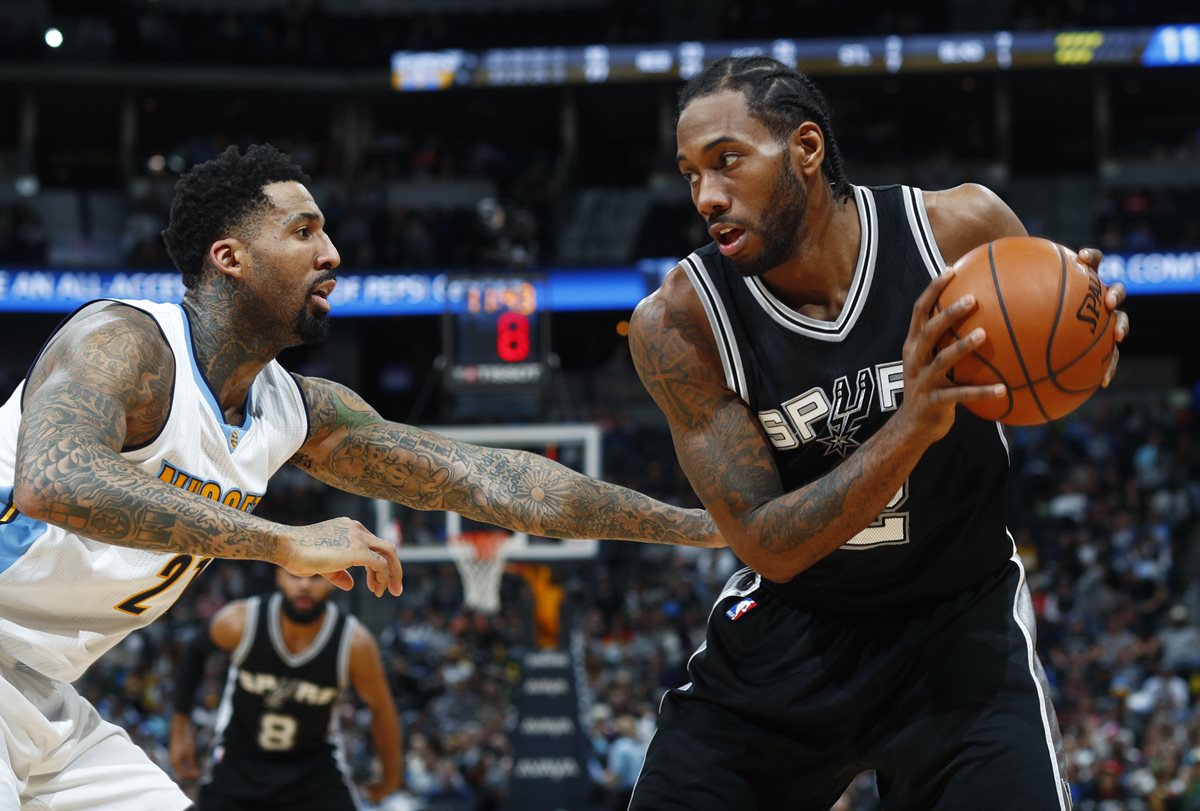 Wilson Chandler, de los Denver Nuggets, intenta detener a Kawhi Leonard de los Spurs, en el duelo que terminó ganando ayer San Antonio (Foto Prensa Libre: AP)