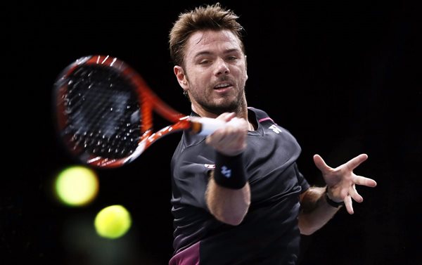 El tenista suizo, Stanislas Wawrinka, devuelve la pelota al australiano Bernard Tomic, en el partido de segunda ronda del torneo de París. (Foto Prensa Libre: EFE)