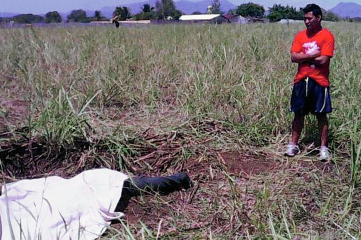 Poblador de  de Escuintla observa el cadáver  de  Jonathan Gómez. (Foto Prensa Libre: Enrique Paredes)