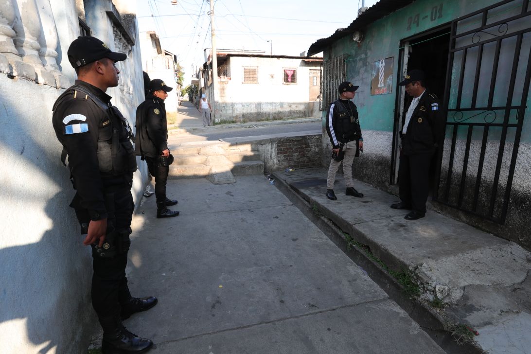 Agentes de la PNC resguardan viviendas durante allanamientos en la capital y al menos siete departamentos. (Foto Prensa Libre: Estuardo Paredes)