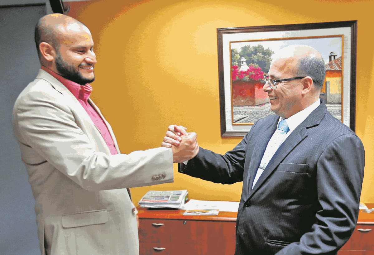 Leonel Villamar, intendente de Fiscalización, felicita a Abel Cruz Calderón, luego de que fue elegido por el Directorio como el administrador tributario para los siguientes cinco años. (Foto Prensa Libre: Esbin García)