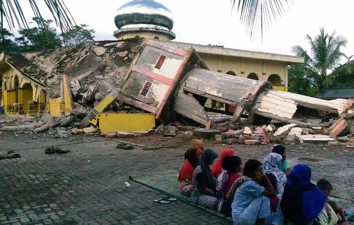 Residentes se reúnen frente a una mezquita dañada en la ciudad de Pidie, provincia de Aceh, en el norte de Sumatra. (Foto Prensa LIbre: AFP).