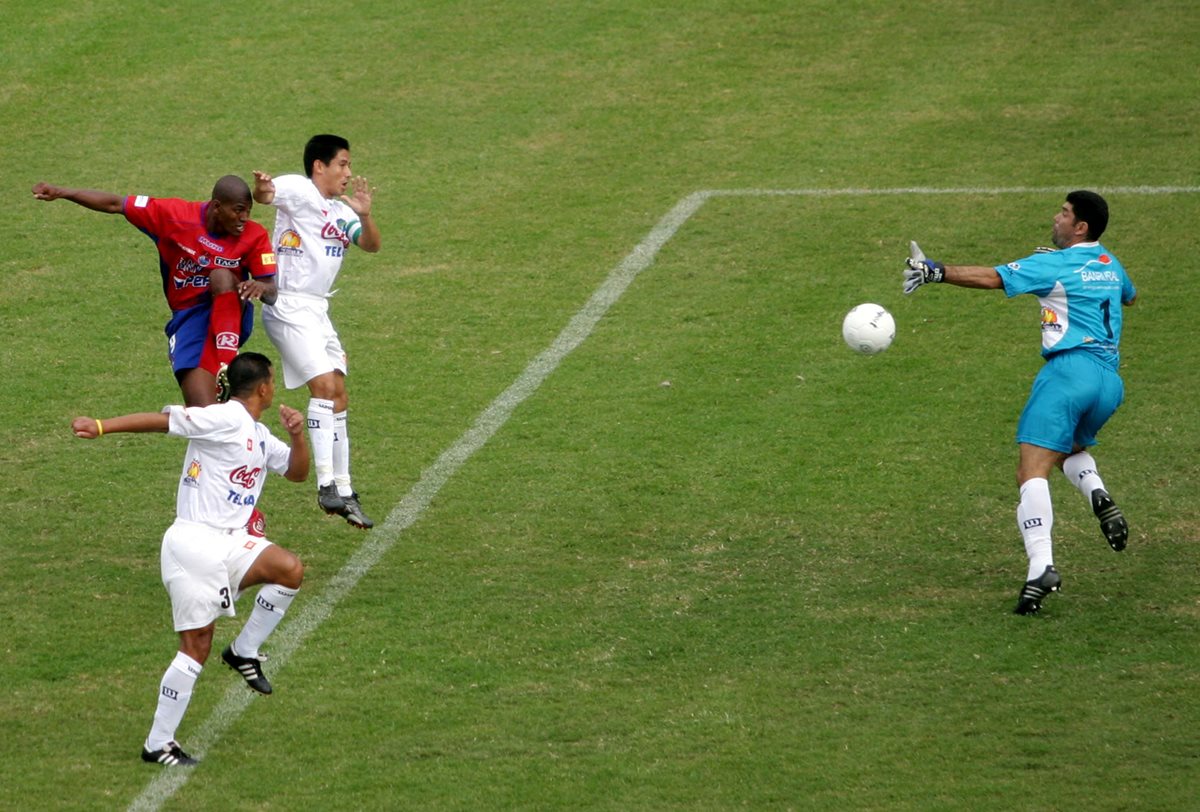 Mario "el Coyote" Acevedo, delantero de Municipal, cabecea frente a Rigoberto Gómez, para conseguir el segundo gol de los rojos en el triunfo por 4-1 en el Clásico 216. (Foto Prensa Libre: Hemeroteca PL)