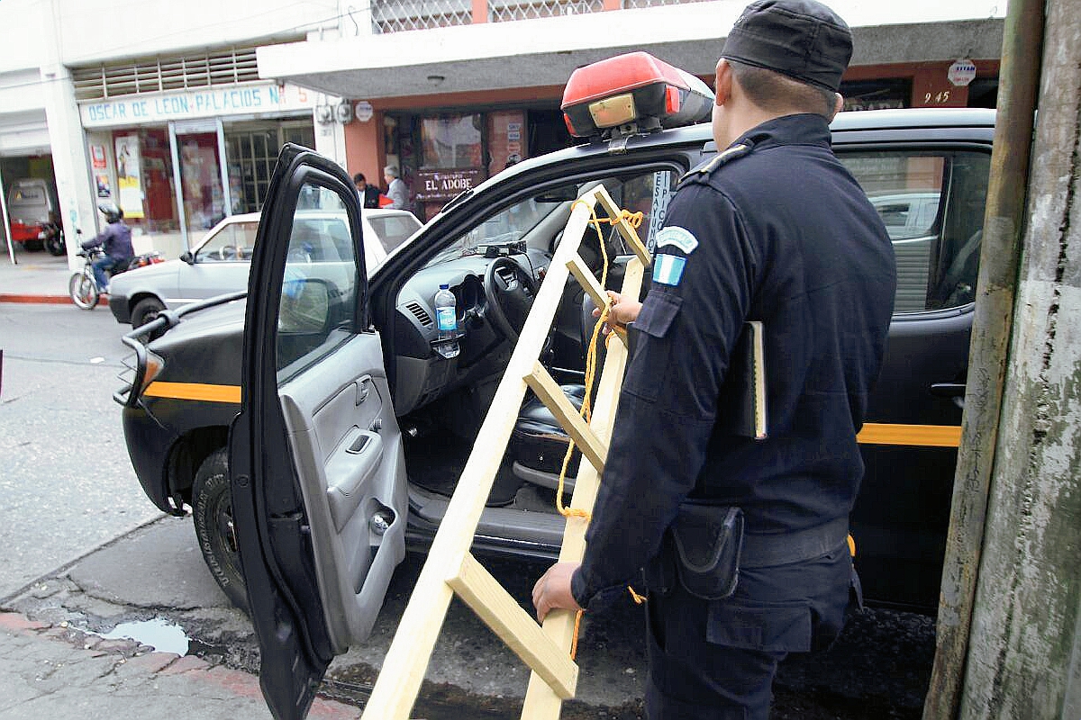 Agentes de la PNC, llevan la escalera encontrada en oficinas de diputados. (Prensa Libre: Erick Ávila).