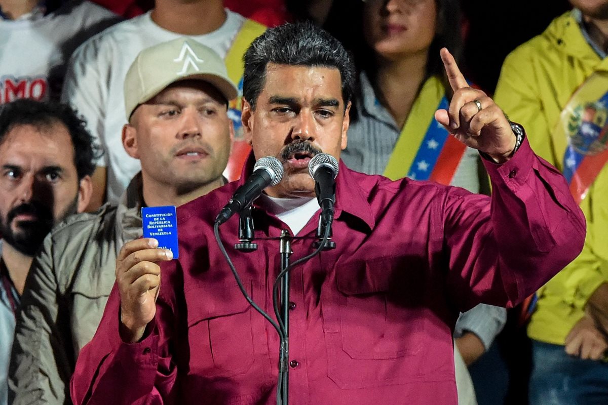 Nicolás Maduro sostiene la Constitución política después de que el Consejo Nacional Electoral (CNE) anunció los resultados de la votación.(Foto Prensa Libre:AFP).