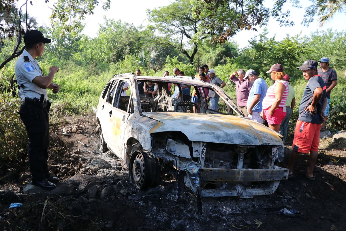 Los cadáveres fueron encontrados en el baúl del vehículo carbonizado. El terreno en que estaba el automóvil es desolado, en un sector del parcelamiento Arizo, Puerto de San José, en Escuintla. (Foto Prensa Libre: Hemeroteca PL)