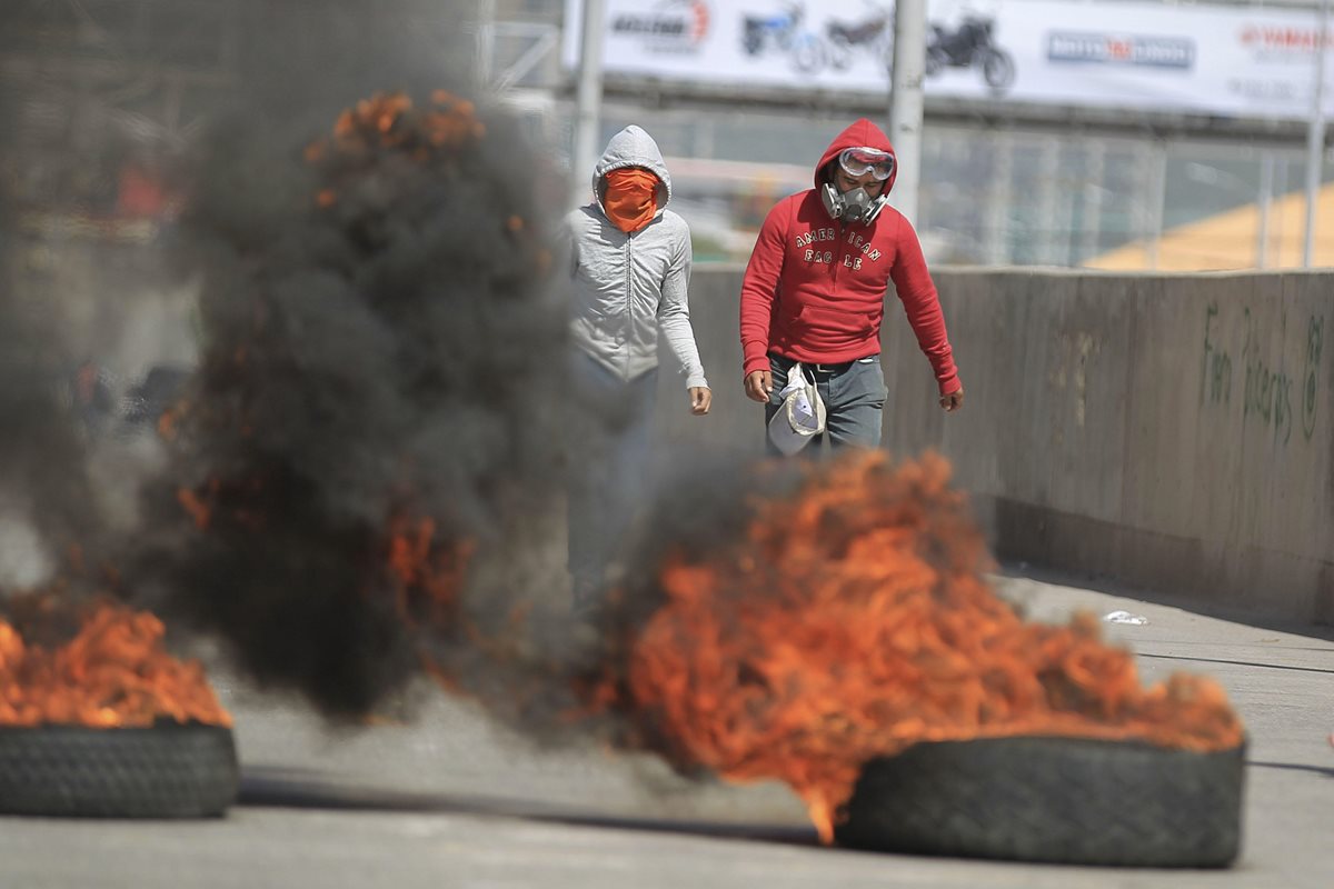 Estudiantes universitarios que apoyan el paro de transporte nacional se enfrentan a la Policía, en Tegucigalpa, Honduras. (Foto Prensa Libre:EFE)