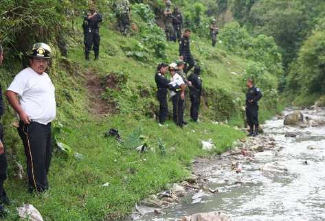 Agentes de   la  PNC y bomberos,  en el lugar donde se localizó  parte del cuerpo de  adolescente.