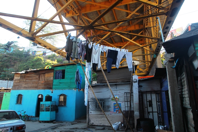 La casa de María, pintada de celeste, se encuentra bajo el puente. Ella y su esposo, Antonio, esperan la noche para vender pollo y papas fritas. (Foto Prensa Libre: Esbin García)