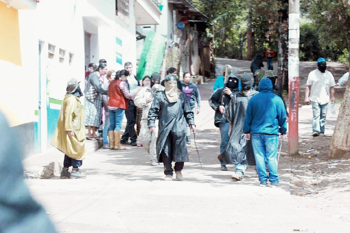 Los encapuchados retienen a dos personas dentro de un centro educativo. (Foto Prensa Libre: Estuardo Paredes)