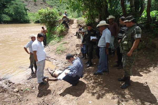 Un agente del MP elabora un acta sobre el hallazgo del cadáver. (Foto Prensa Libre: Edwin Paxtor)<br _mce_bogus="1"/>