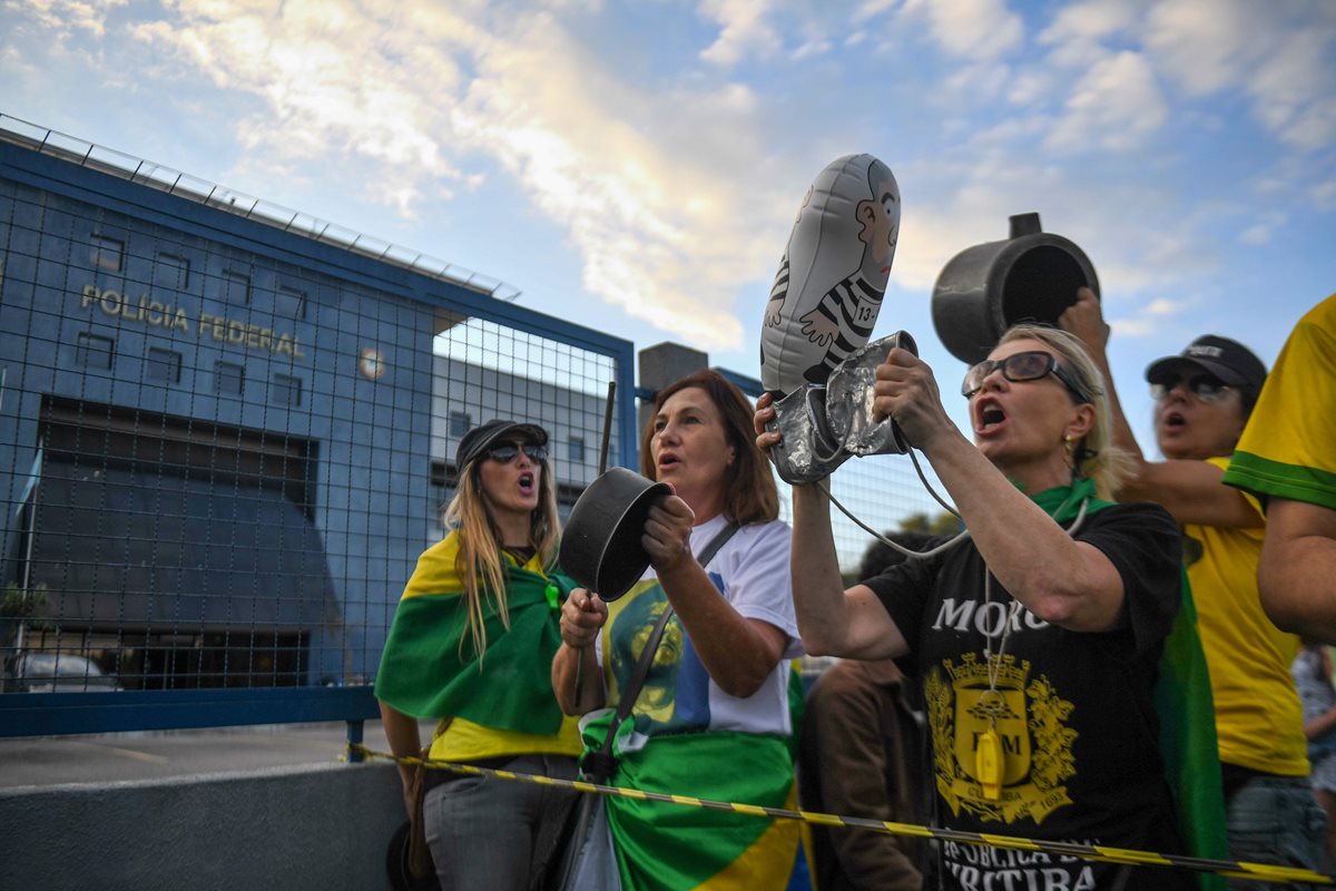 Opositores del ex presidente brasileño (2003-2011) Luiz Inácio Lula da Silva gritan consignas mientras esperan frente a la sede de la Policía Federal, donde debe comenzar su sentencia de 12 años de prisión, en Curitiba, estado de Paraná, Brasil.