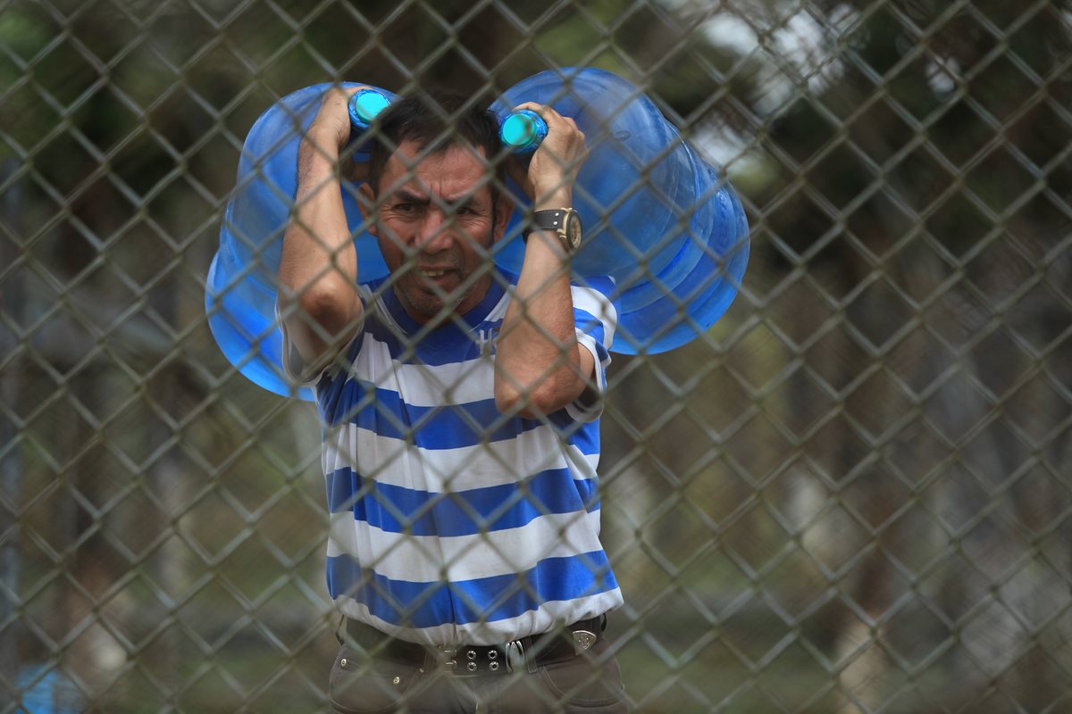 Algunos de los internos reciben agua en garrafones. Piden a las autoridades agilizar la reparación de la bomba.(Foto Prensa Libre: Esbin García)