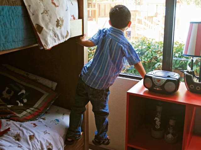 uno de los pequeños, que por ahora carece de una familia, observa por el ventanal de uno de los hogares de protección. Como él, muchos tienen la esperanza de ser elegidos como hijos.