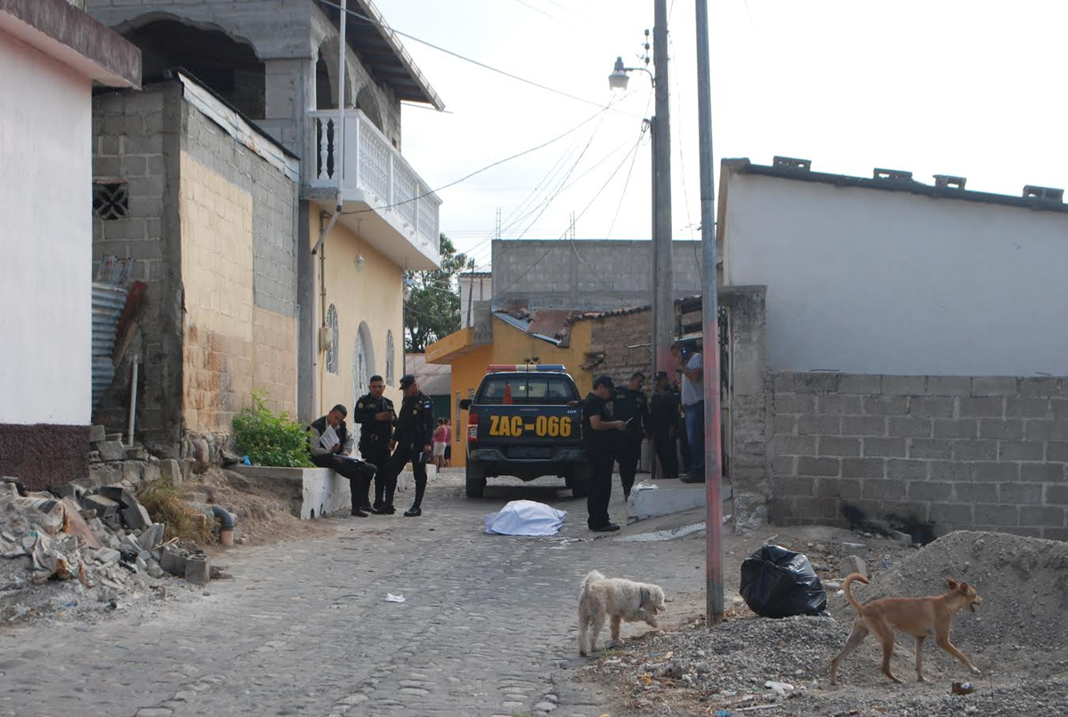 Agentes de PNC vigilan el área donde ocurrió el crimen. (Foto Prensa Libre: Mario Morales)