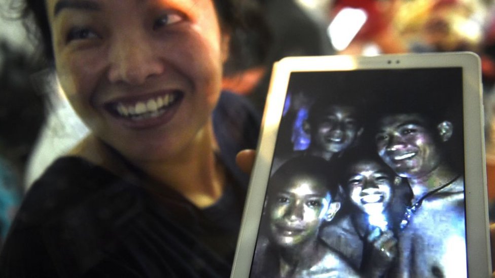 Una madre de los niños que estaban atrapados en la cueva Tham Luang muestra una tableta en la cual observa las condiciones en las que permanecían los menores. (Foto Prensa Libre: Getty Images)