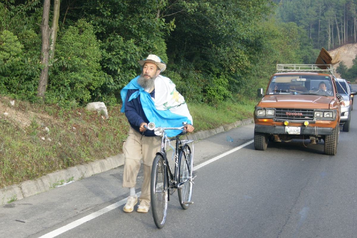 Oswaldo Ochoa Calderón, de 65 años, quien el domingo 14 salió de la ciudad de Quetzaltenango a pie hacia la capital, para protestar contra la corrupción, recorre algunos tramos en bicicleta.