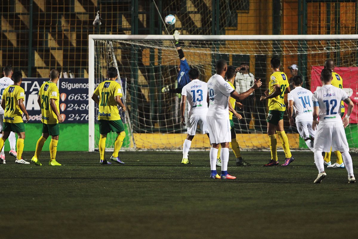 El portero costarricense de Petapa, Víctor Bolívar, se esfuerza al máximo para detener un colocado remate de Manfred Russell, de Comunicaciones, en el juego celebrado en el estadio Julio Cóbar. (Foto Prensa Libre: Norvin Mendoza)