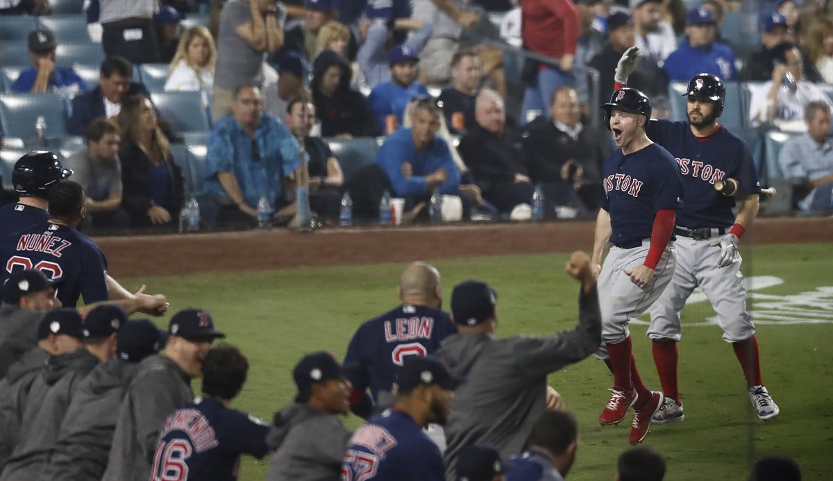 Brock Holt (segundo a la derecha) celebra después de haber conseguido una carrera impulsada por un jonrón de Rafael Devers este sábado, en el cuarto duelo del Clásico de Otoño entre Medias Rojas y Los Dodgers (Foto Prensa Libre: EFE)