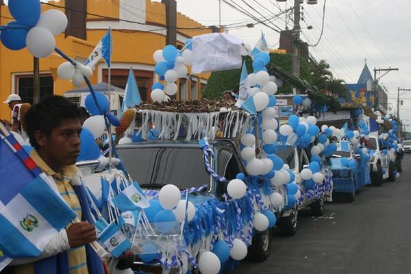 Vehículos cubiertos en colores azul y blanco participan en las caravanas. (Foto Prensa Libre: Angel Martín Tax)