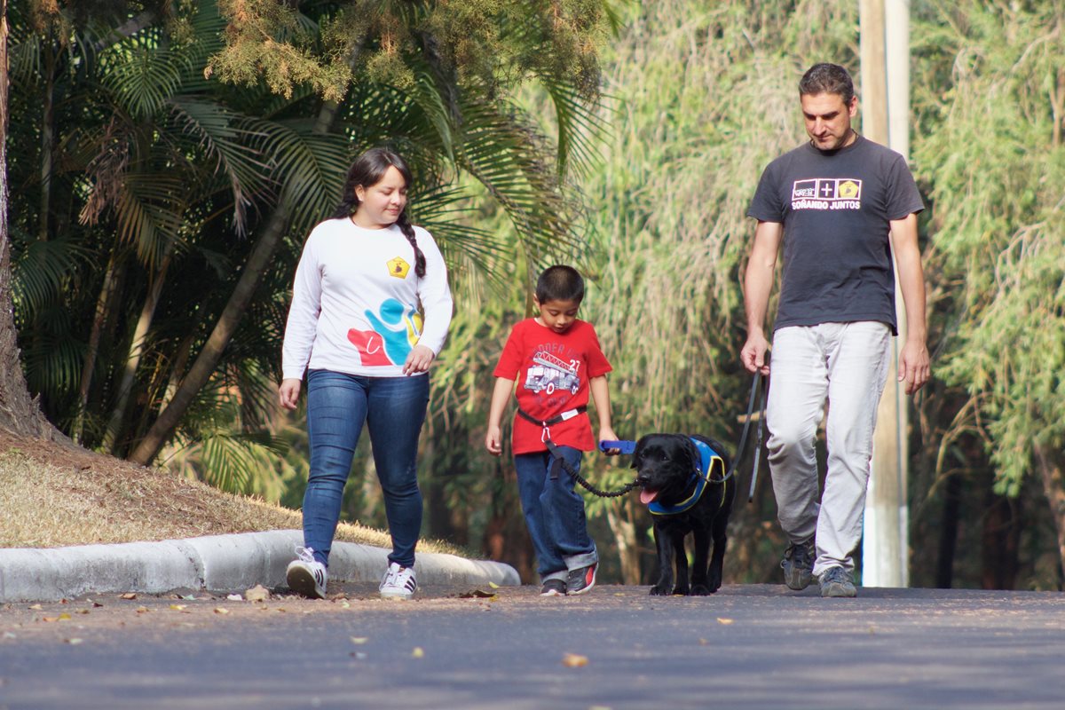 Juan Diego y Kimono caminan unidos por un cinturón para evitar que el niño salga corriendo en la calle. (Foto Prensa Libre: Fundación Waybi-Bocalan)