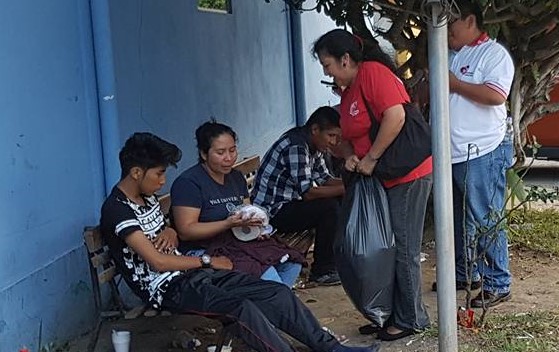 Una voluntaria entre ayuda a personas que esperan a sus pacientes frente al Hospital Roosevelt. (Foto Prensa Libre: Cortesía).