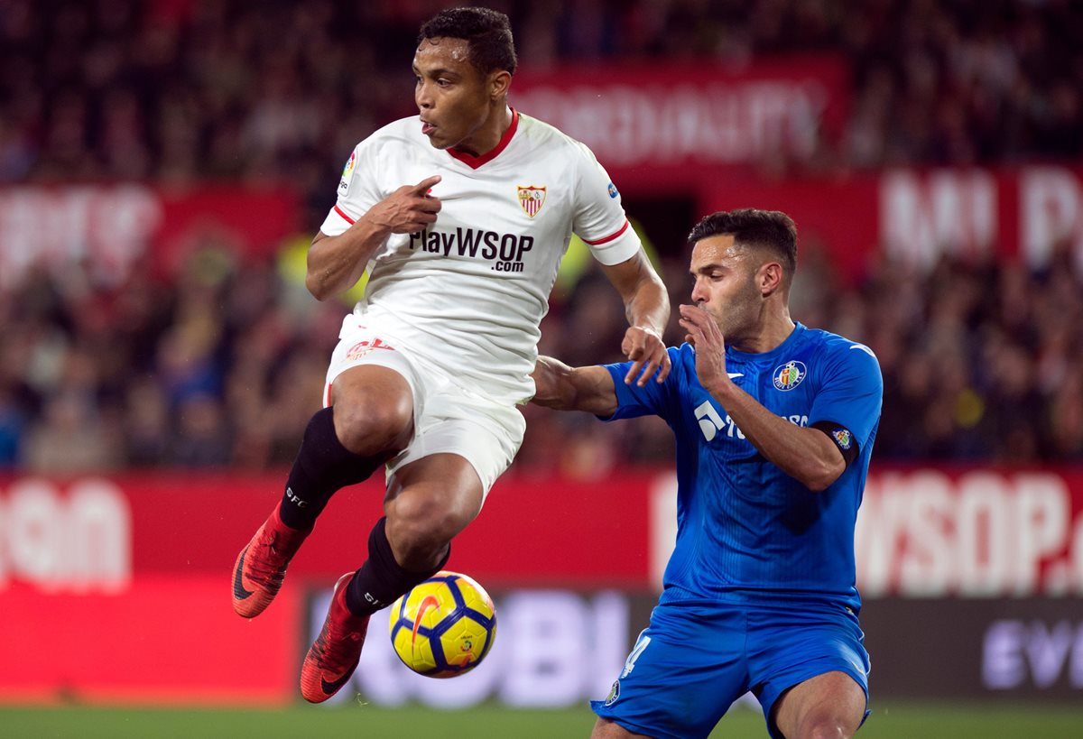 Luis Muriel del Sevilla salta con el balón frente a  Bruno González del Getafe. (Foto Prensa Libre: AFP)